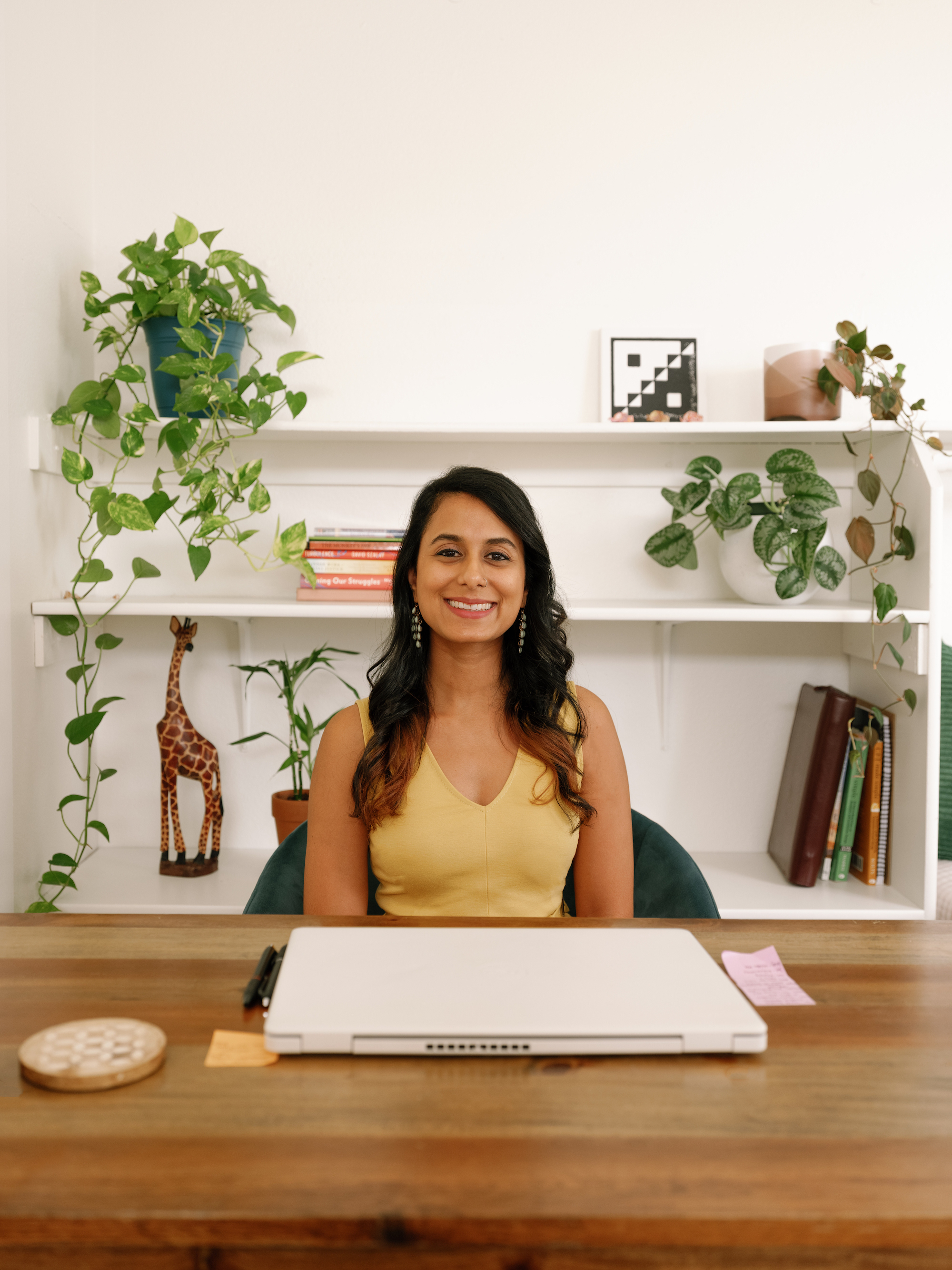 A smiling Alma provider sits at her desk