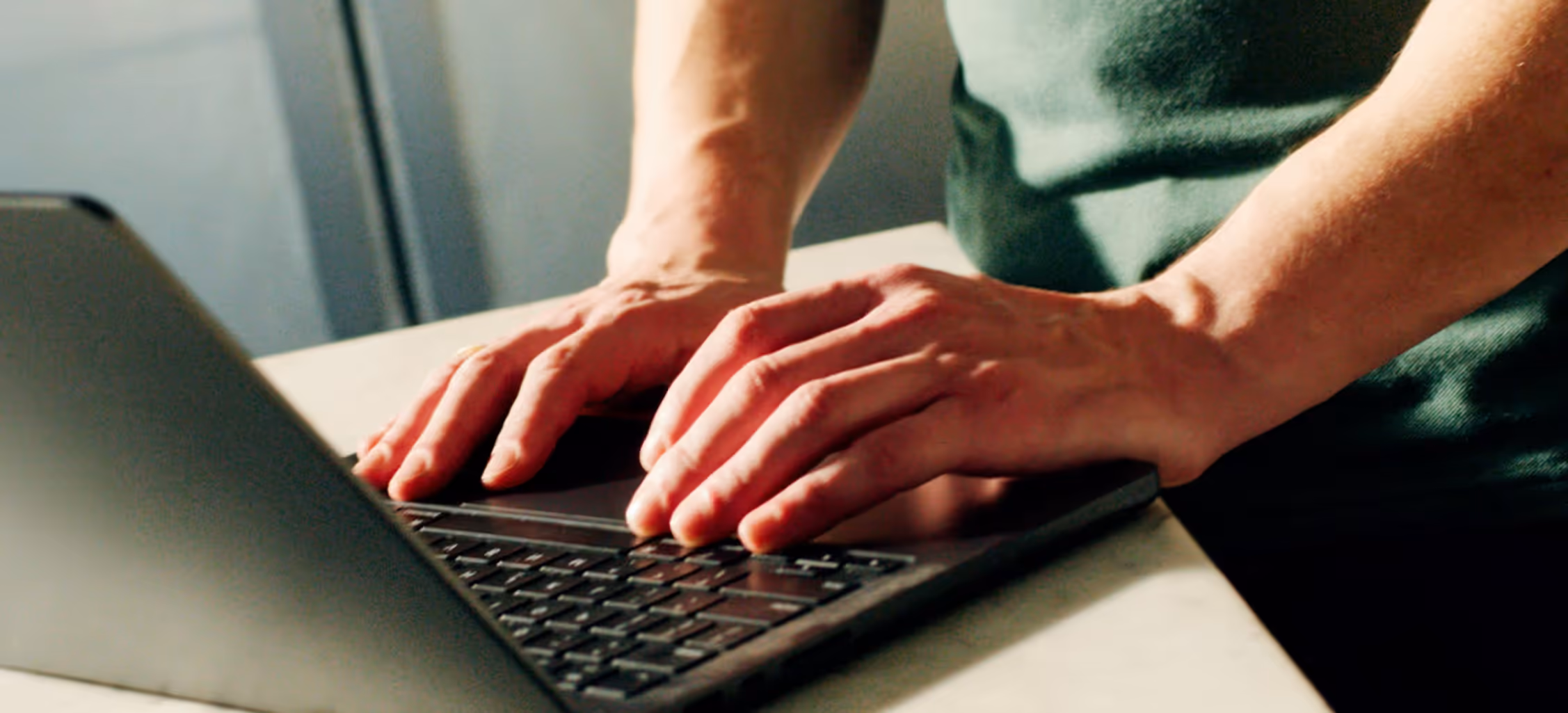 A pair of hands typing on a laptop keyboard